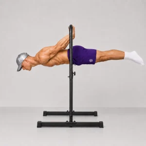 Kal holding a full back lever from a pull-up bar with straight arms and his body horizontal facing the floor